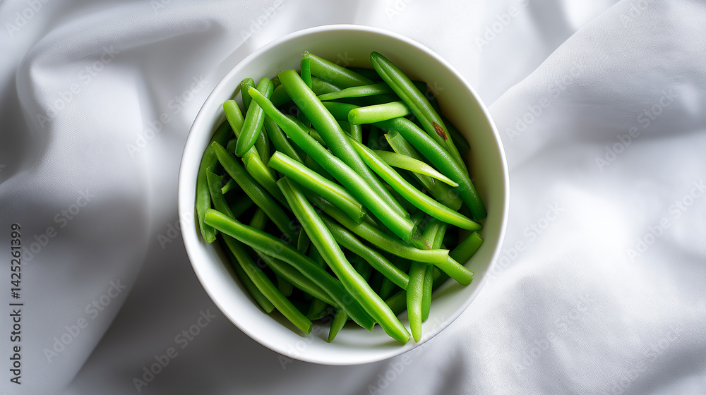 Fresh green beans neatly arranged in a white bowl on a bright white background.
