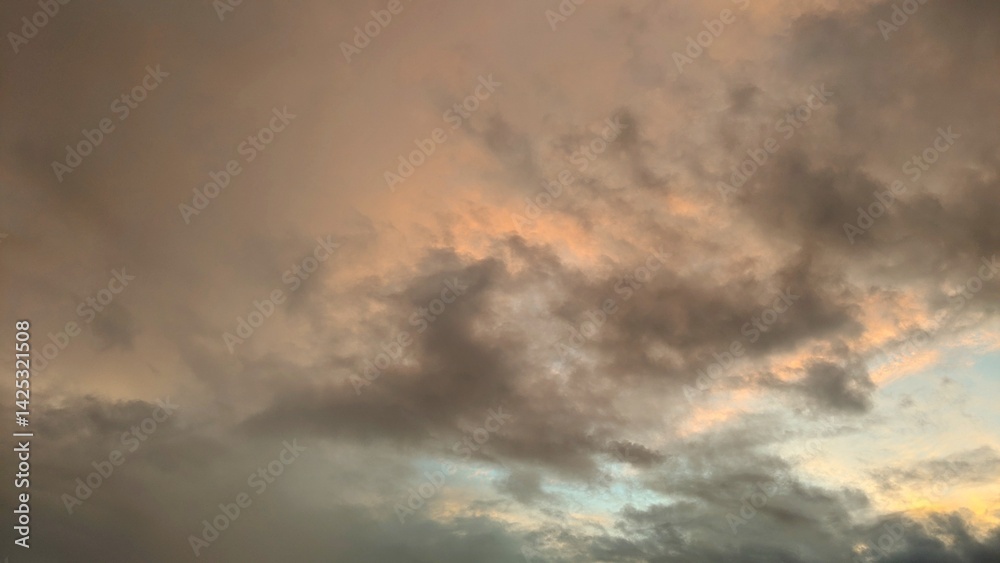 Golden and grey clouds fill the frame, illuminated from within. The light creates a dramatic effect, highlighting the texture and form of the cloudscape. Golden and grey clouds fill the frame, illuminated from within. The light creates a dramatic effect, highlighting the texture and form of the cloudscape.