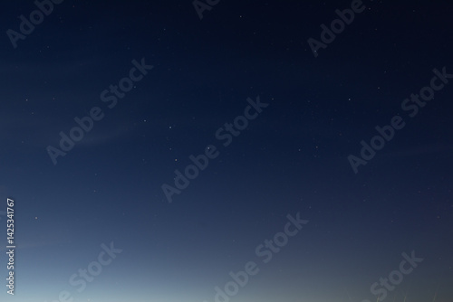 Fototapeta Naklejka Na Ścianę i Meble -  A clear night sky filled with visible stars gradually fades into a soft horizon glow, creating a tranquil and minimal celestial scene copy space present.