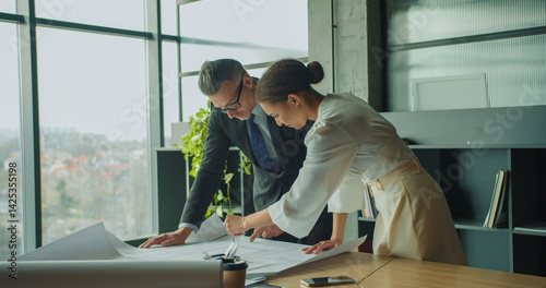 Architects discussing floor plan in modern office