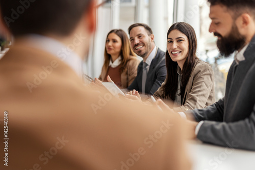 Obraz na płótnie Selective focus on smiling businesswoman sitting at meeting room surrounded by colleagues. w salonie