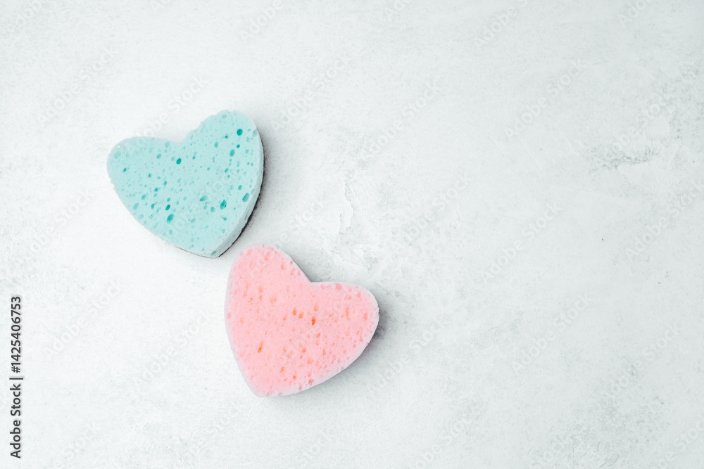Colorful heart-shaped sponges on a light textured background