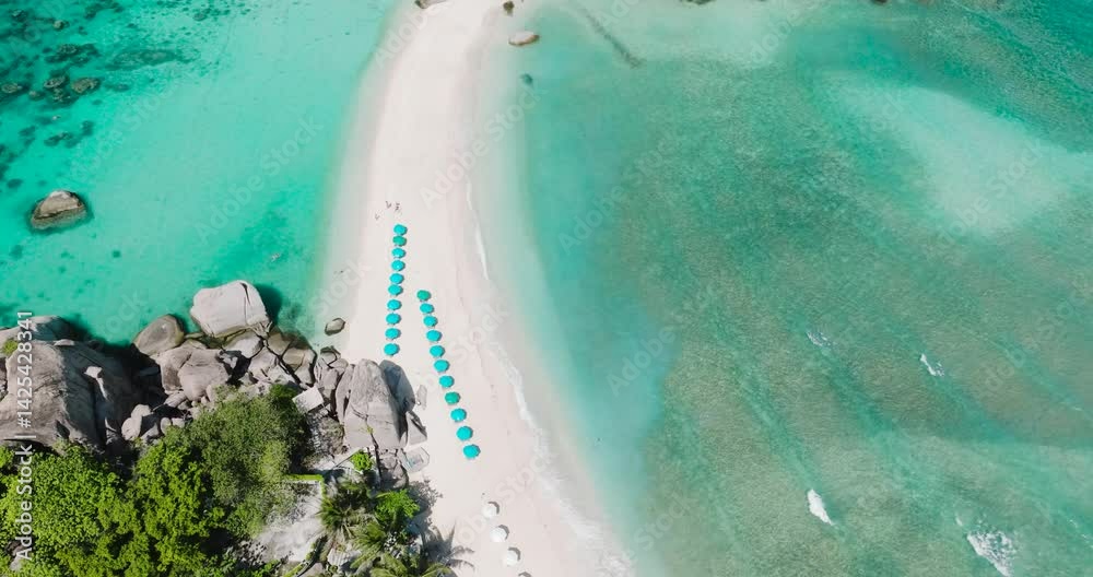 Island shoreline featuring turquoise waters, rocky formations and vibrant tropical greenery. Nangyuan Island Beach, Koh Tao, Thailand.