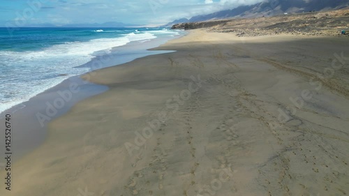 Wallpaper Mural An aerial view of Cofete Beach, revealing a woman walking along the sand in spectacular scenery. Fuerteventura, Canary Islands, Spain. Torontodigital.ca