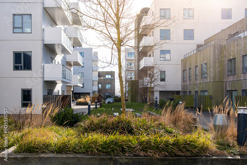 Low-rise buildings in Ørestad, Copenhagen with planted public space and soft landscape. Urban ecology integrated with modern residential design.