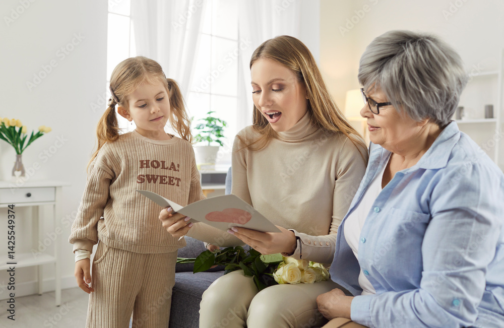 Three female generations family fun at home card getting with heart love, cute little granddaughter girl, mother, grandmother, beloved granny, funny grandchild, young mom enjoy leisure time together