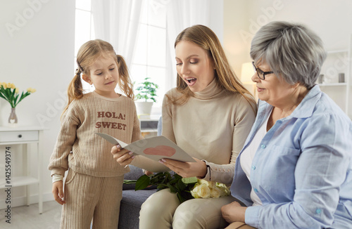 Obraz na płótnie Three female generations family fun at home card getting with heart love, cute little granddaughter girl, mother, grandmother, beloved granny, funny grandchild, young mom enjoy leisure time together w salonie