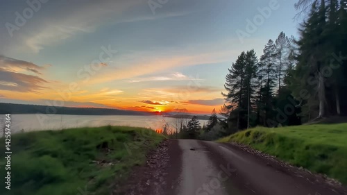 there is a car driving down a dirt road in the woods