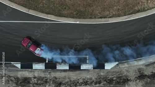 Aerial view car drift on asphalt race track with lot of smoke from burning wheel tires rubber, Drift motorsport car drift race, Professional driver drift car on asphalt race track, Car motion blurred 