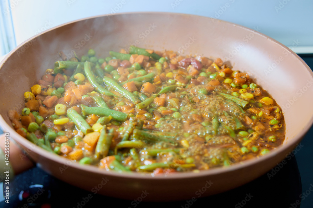 vegetables are cooked in a frying pan in a home kitchen vegetables are cooked in a frying pan in a home kitchen
