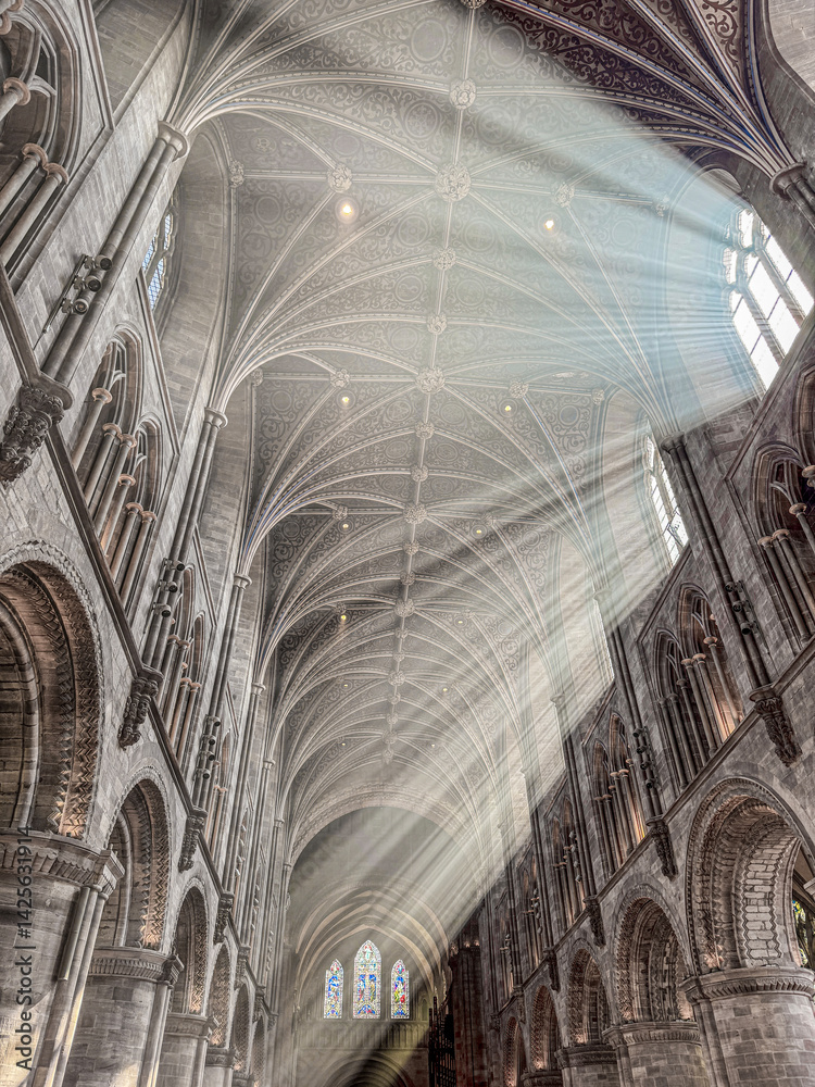 The vaulted ceiling of Hereford Cathedral, Herefordshire, England UK. The sun beams are visible in the incense smoke of the Easter Sunday morning service.