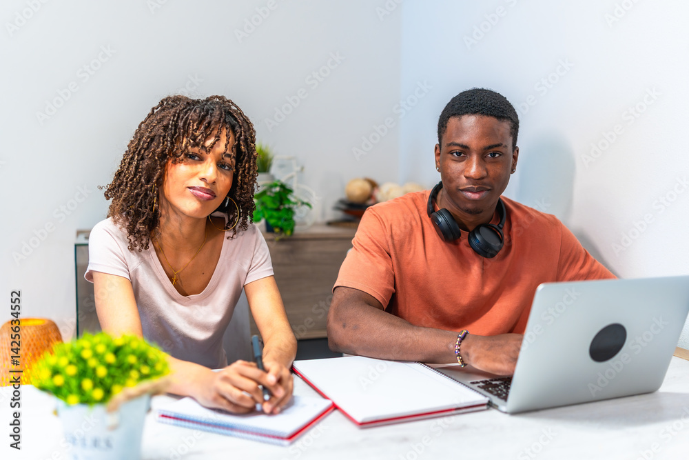 Students working at home using laptop and taking notes