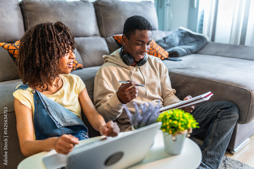 Students doing homework together at home using laptop and notebooks