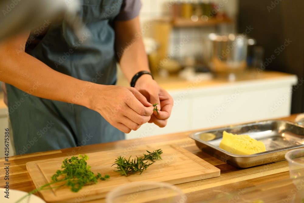 Obraz premium Chef preparing fresh herbs on cutting board to mix into homemade butter