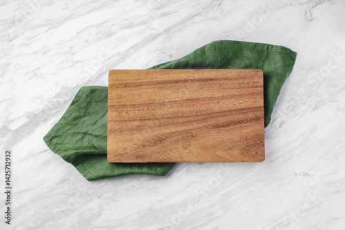 Wood board on green kitchen cloth on natural marble table