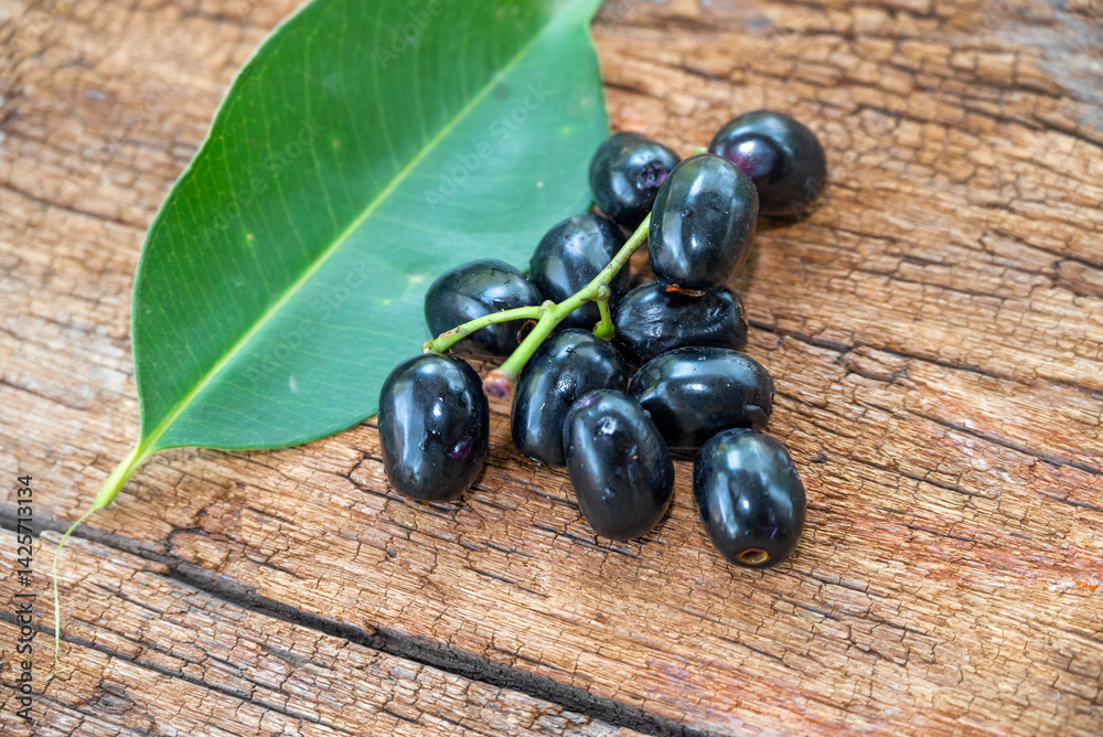 Jambolan plum, Java plum, Jambul( Syzygium cumini (L.) Skeels. on wooden background Jambolan plum, Java plum, Jambul( Syzygium cumini (L.) Skeels. on wooden background