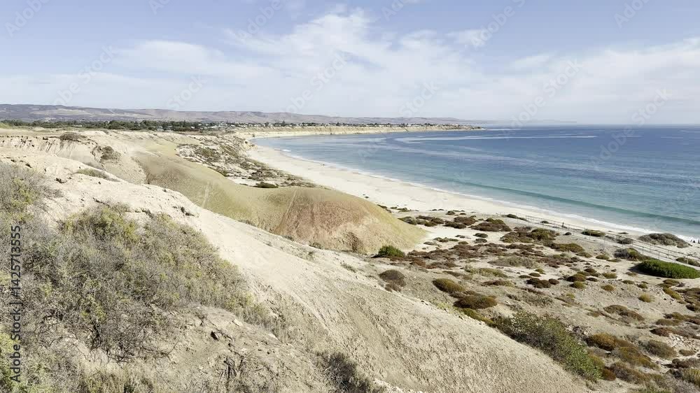 Waves slowly crashing on sandy shore. Panoramic view of Maslin Beach with its turquoise clear waters and massive cliffs in background. Fleurieu Peninsula, Onkaparinga, Adelaide, South Australia Waves slowly crashing on sandy shore. Panoramic view of Maslin Beach with its turquoise clear waters and massive cliffs in background. Fleurieu Peninsula, Onkaparinga, Adelaide, South Australia