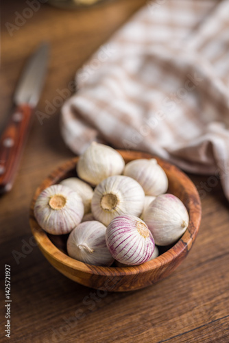 Fototapeta Naklejka Na Ścianę i Meble -  Solo glove garlic bulbs in bowl on wooden table.