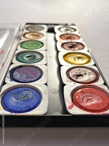 Different set of watercolors in the box on a white background