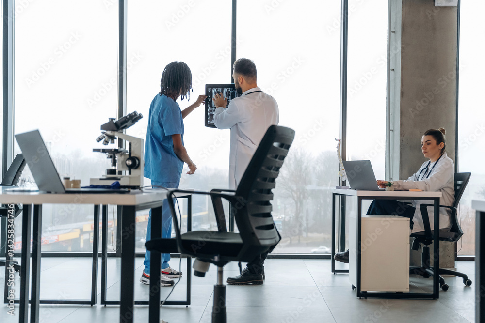 X-ray in hands, researching. Doctors are in the clinic X-ray in hands, researching. Doctors are in the clinic