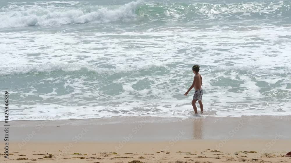 boy on vacation spending time on the beach, boy playing with waves on the beach boy on vacation spending time on the beach, boy playing with waves on the beach