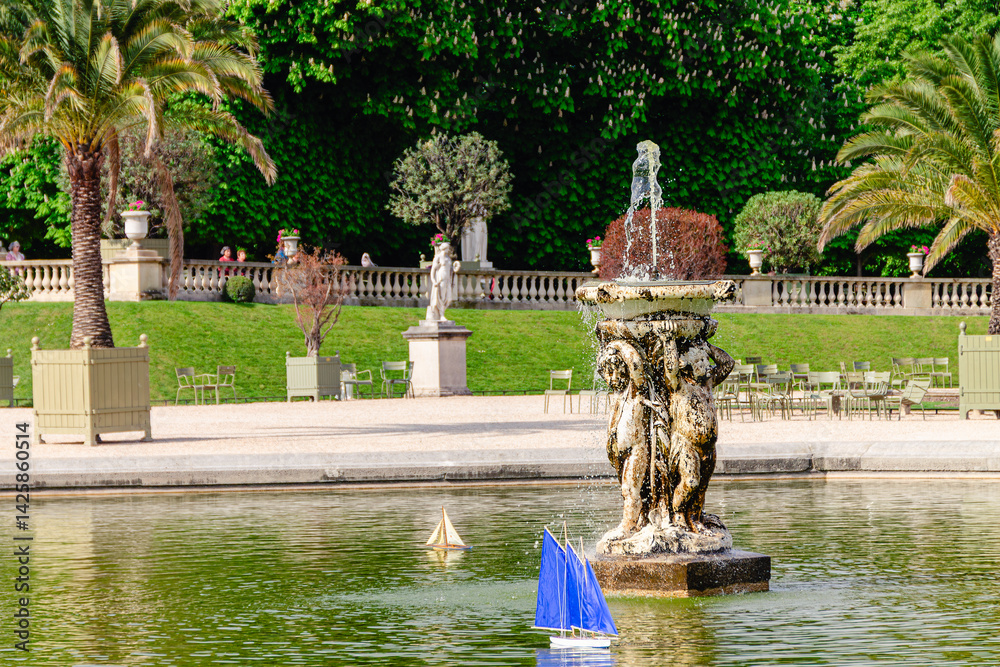 Model sailing boats glide across the pond in the Garden Luxembourg.