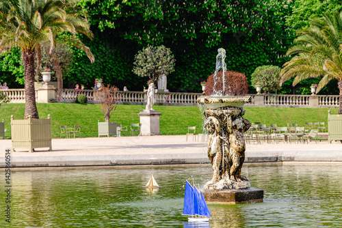Obraz na płótnie Model sailing boats glide across the pond in the Garden Luxembourg. w salonie