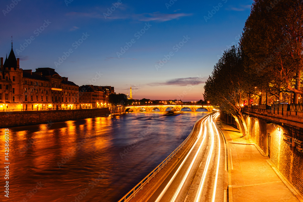 View of Paris by night with the Seine river and the Conciergerie building