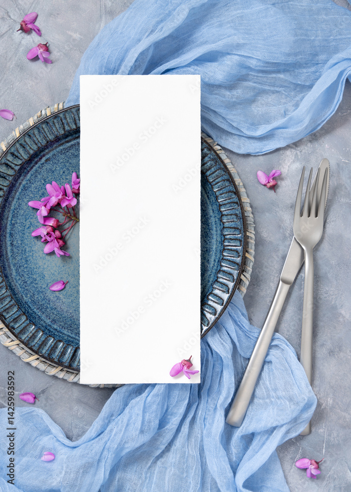 Wedding table place with a card near fabric and wild purple flowers top view on gray, spring mockup