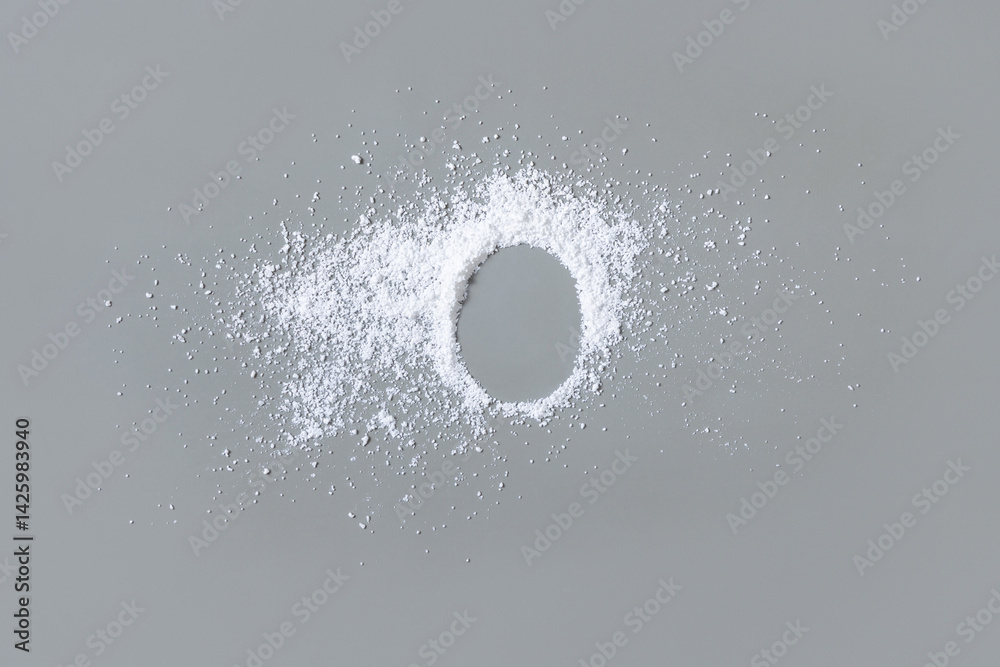 White powder on grey with copy space in middle top view. Dietary supplement or kitchen spice