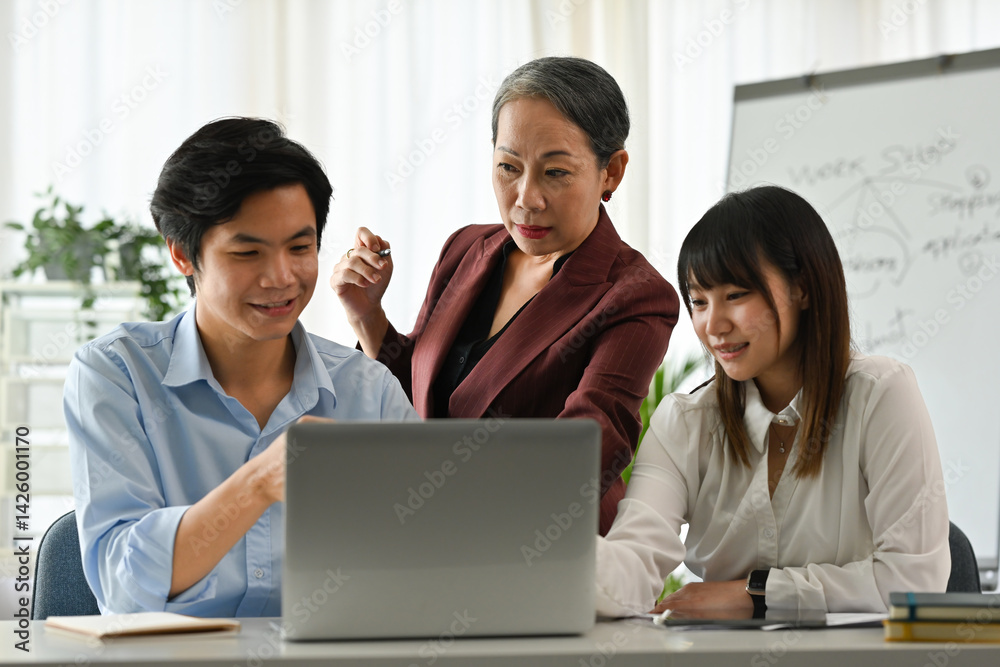 Diverse Age Team Brainstorming and Reviewing Project on Laptop Diverse Age Team Brainstorming and Reviewing Project on Laptop