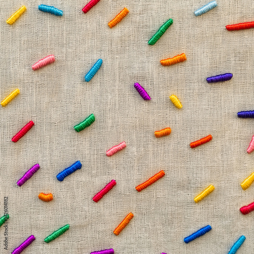 Multicolored splashes of thread on a linen background