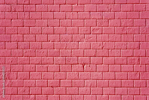 Pink brick wall with brick pattern. Bricks are laid in even rows.