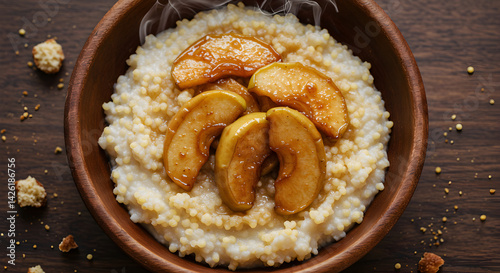 Rustic Warm Millet Porridge Topped With Cinnamon Glazed Apples in Wooden Bowl