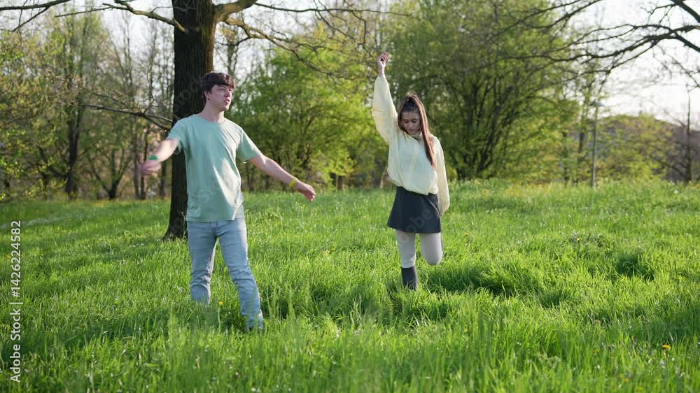 A Young Couple Joyfully Exploring the Beauty of Nature in a Sunny Field Together A Young Couple Joyfully Exploring the Beauty of Nature in a Sunny Field Together
