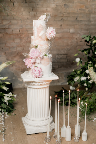 Wedding cake decorated with flowers near the arch