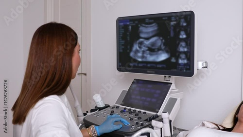 The pregnant woman is lying down in a hospital, doctor using ultrasound equipment screening of pregnant woman. Patient at ultrasonography examination. Family planning and IVF centers concept. Footage