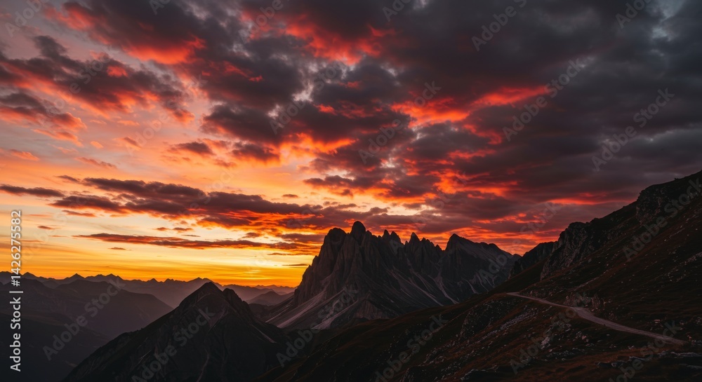 Naklejka premium Golden Hour Over Majestic Peaks - Dramatic sunset paints the sky with fiery hues, casting long shadows across rugged mountains. Symbolizing: adventure, serenity, power, beauty, hope