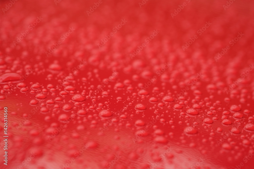 water droplets on the surface of a red shiny surface water droplets on the surface of a red shiny surface