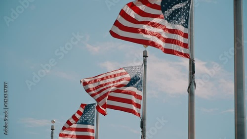Multiple American Flags Waving Against Blue Sky