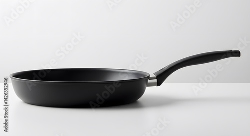 AI image presenting a side profile view of a black non-stick frying pan resting on a clean white table or surface.
