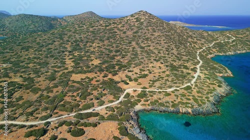 High angle view of rugged hills, coastal road, and clear blue sea in Crete.
