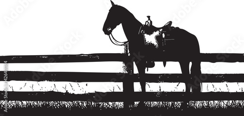 Black silhouette of a saddled horse standing beside a wooden fence on a grassy pasture