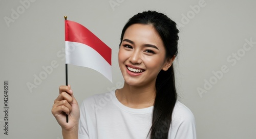 Smiling woman holding Indonesian flag for national day celebration and holiday