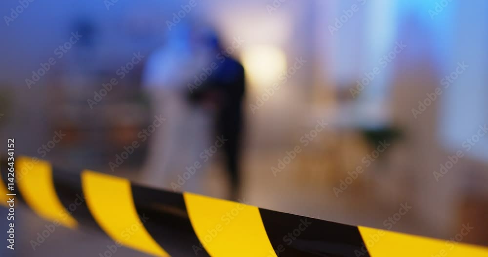 Close up cropped view of bright caution tape marking restricted area of crime scene on blurred background with red blue lights flashing. Police investigation, evidences gathering, forensic examination