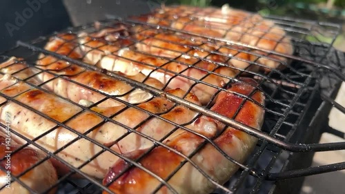 Grilled sausages. Sausages are grilled over an open fire. Frying sausages over coals. Outdoor barbecue sausages.