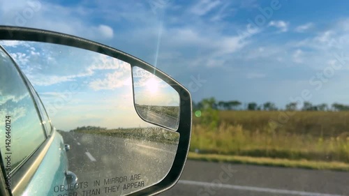 View in the rear view mirror of a car. Road trip. Summer car trip. Road adventure. Summer road trip