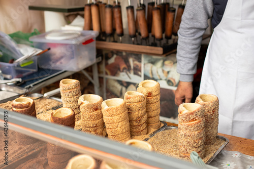 Traditional chimney cakes on display at a street market stall. Chimney cakes with sugar and nuts.