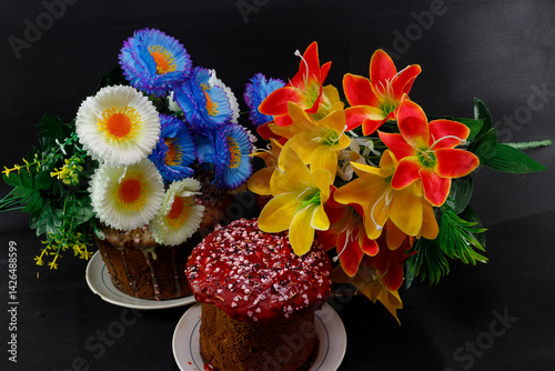 View of colorful flowers with Easter cakes on a black background