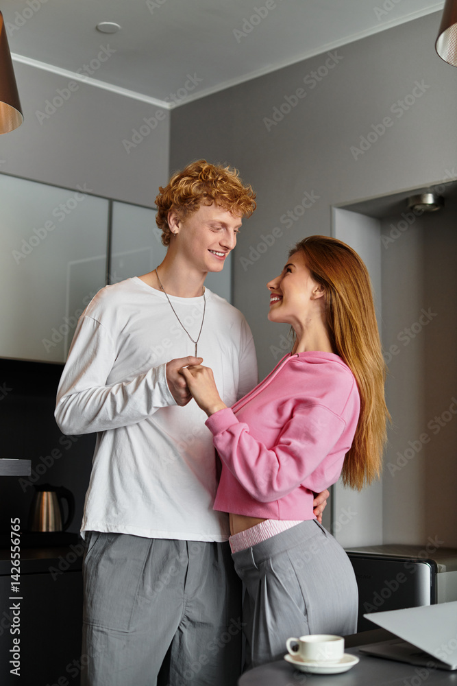 Young couple shares a romantic moment in a stylish hotel room filled with love and laughter